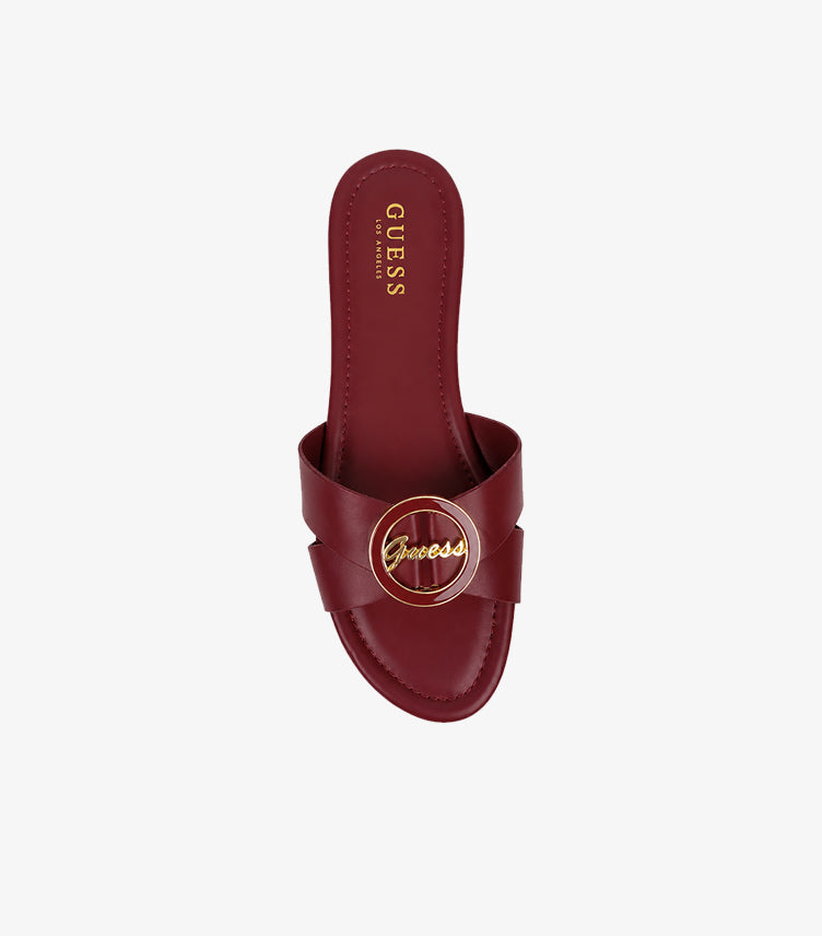 GUESS Los Angeles burgundy cross-strap flat slides top-down view showing gold script medallion and GUESS LOS ANGELES branded insole