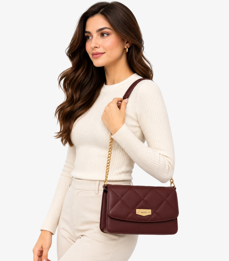ALDO Women's Burgundy Quilted Crossbody Bag styled on a female model, featuring a gold chain shoulder strap and elegant diamond stitching.