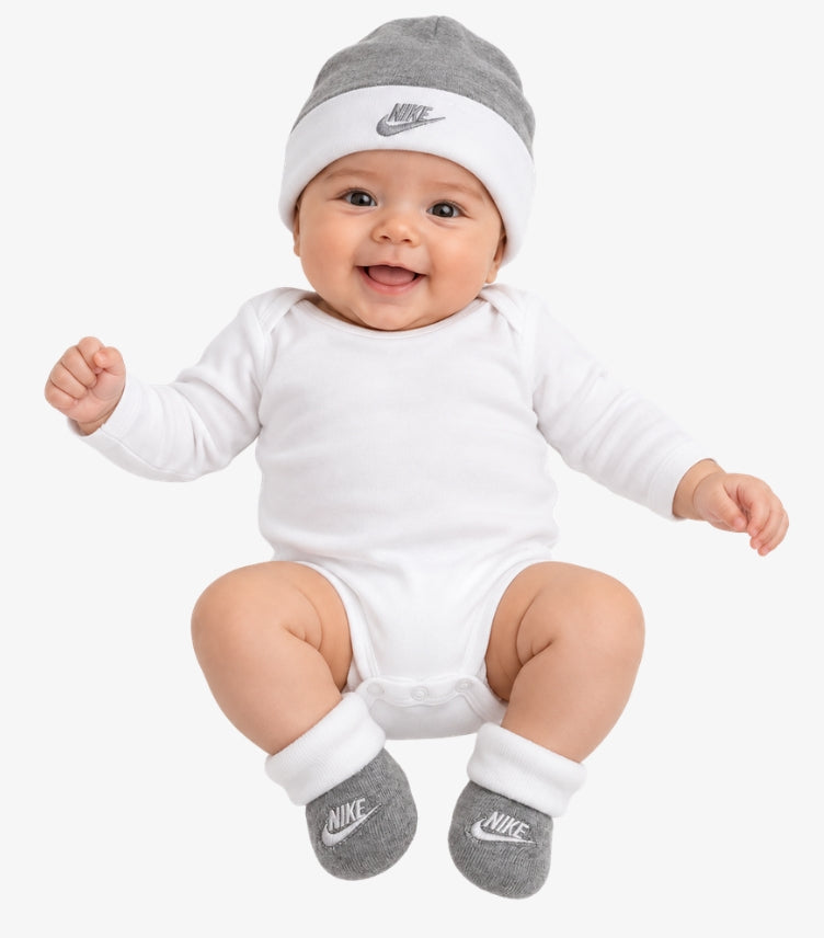 Baby wearing a grey and white Nike beanie with matching embroidered logo booties
