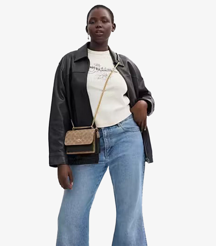 Close-up of gold-tone chain strap on Coach Mini Klare Signature canvas crossbody bag