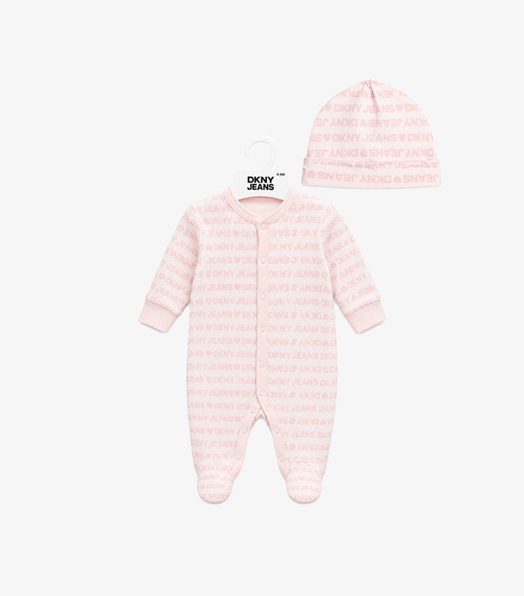 Front view of DKNY Jeans baby girls’ pale pink logo-print footed sleepsuit and matching hat set.