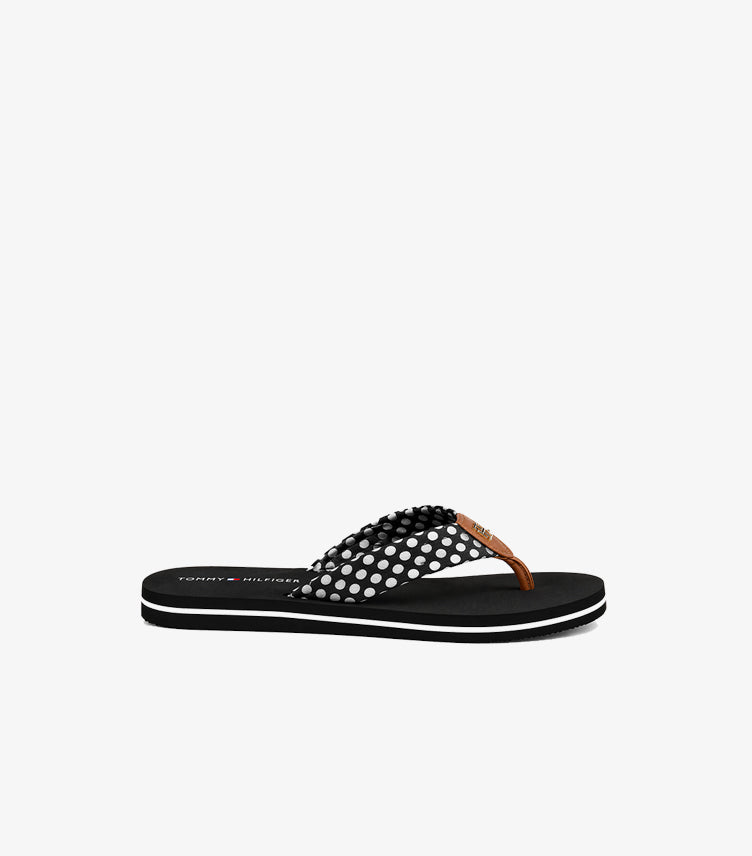 Side view of Tommy Hilfiger polka dot thong sandal showing the flat sole and contrast midsole stripe