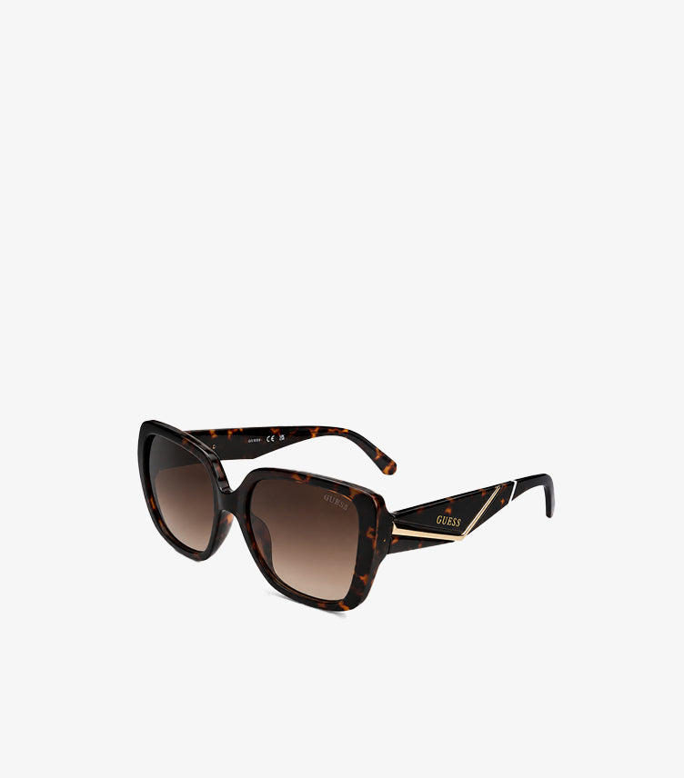 Angled view of Guess women’s tortoiseshell oversized square sunglasses with brown gradient lenses and black logo arms