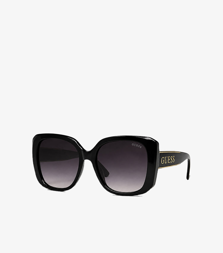 Angled view of Guess women's oversized square designer sunglasses featuring gradient lenses and signature Guess logo on the temples.