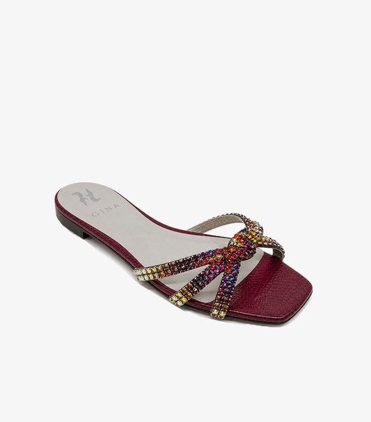 Angled view of GINA women’s crystal-embellished flat sandal with textured burgundy footbed