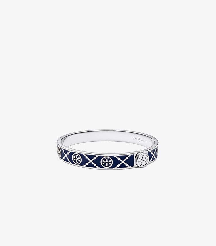 Angled front view of Tory Burch navy enamel and silver-tone bangle with repeating Double T logos and lattice pattern