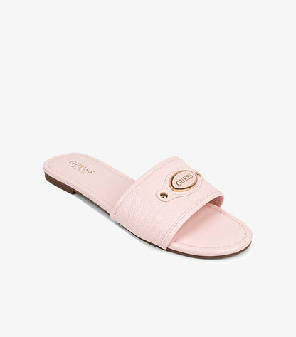 GUESS Los Angeles baby pink pebbled leather wide-strap flat slide sandal angled view showing oval gold logo plaque and stud rivets