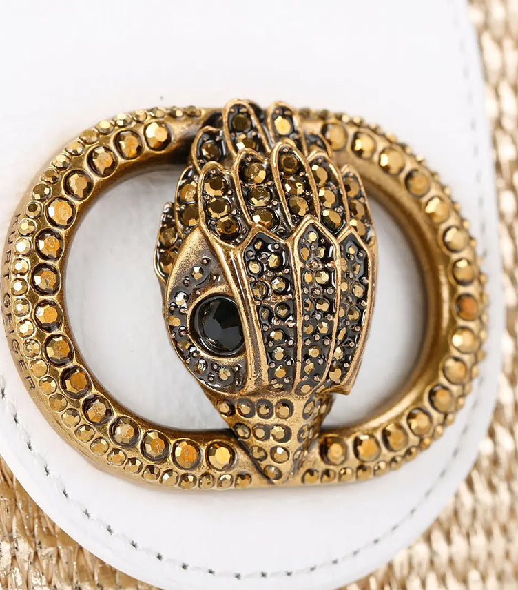 Close-up of Kurt Geiger Micro Chelsea Hobo bag showing its crystal-embellished antique brass eagle head