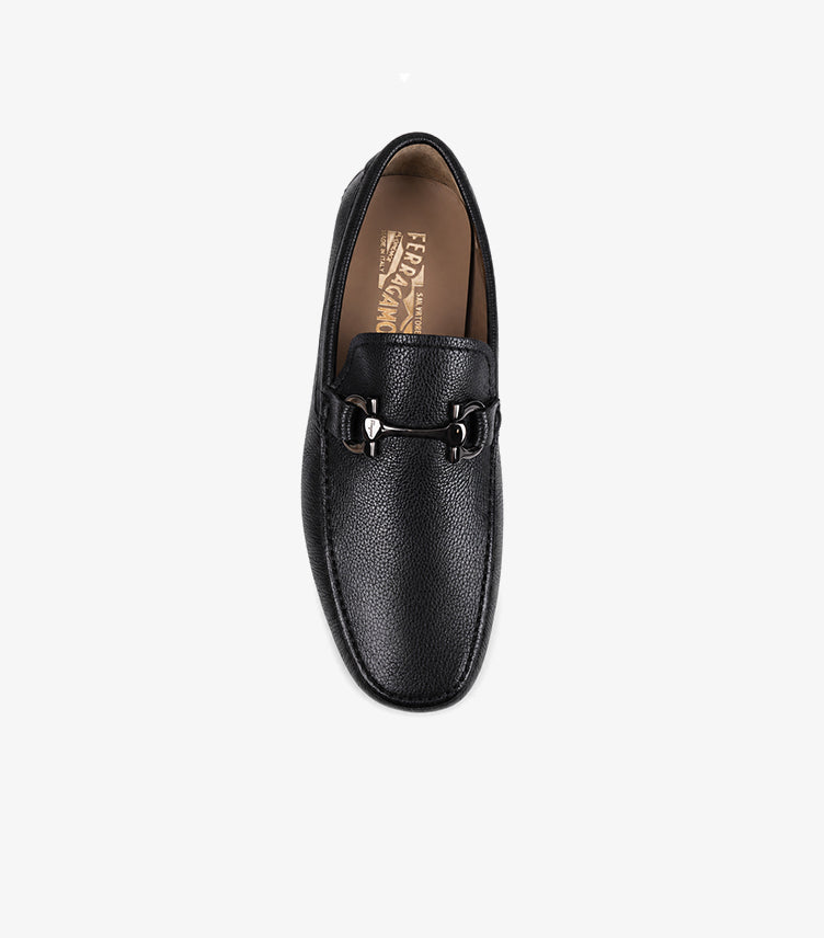 Ferragamo men's black pebbled leather Gancini driving loafer top-down view showing gunmetal Gancini hardware and FERRAGAMO Salvatore Made in Italy branded insole