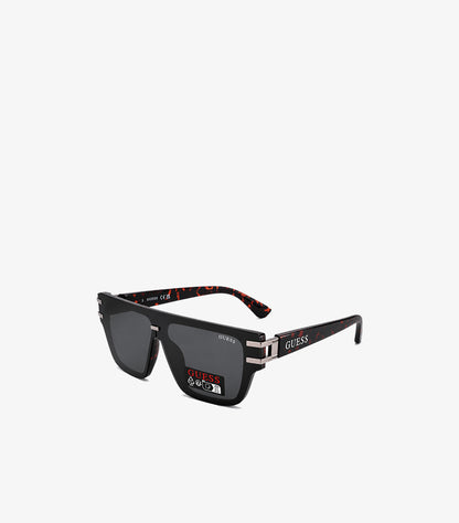 GUESS black flat-top square sunglasses angled view showing tortoiseshell red-brown temple interior silver hardware and GUESS temple branding