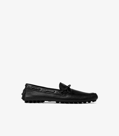 Side view of Prada men’s textured leather driving moccasin with bow detail and rubber-studded sole