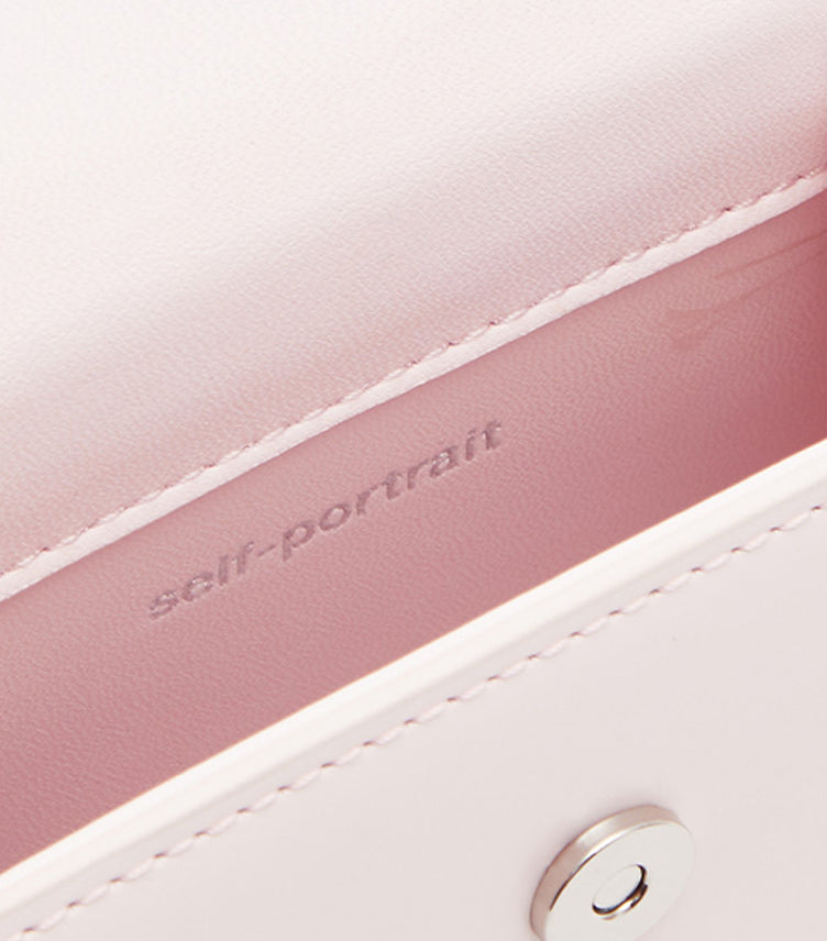 Self-Portrait pink satin interior lining with embossed self-portrait branding and silver snap closure