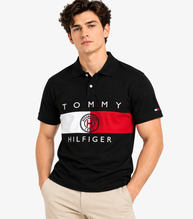 Man wearing a Tommy Hilfiger black short-sleeve polo shirt with red and white colour-block panels, logo lettering and chest crest