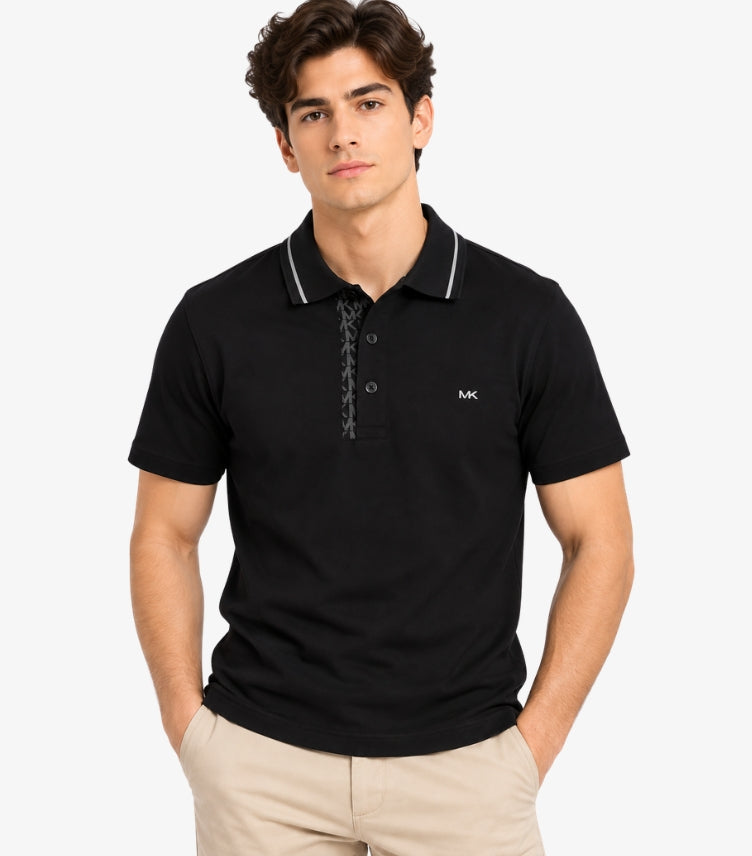 Man wearing a Michael Kors black short-sleeve polo shirt with grey collar piping, tonal MK monogram placket and chest logo