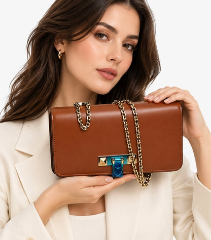Front view of a Valentino brown structured flap bag with gold-tone pyramid studs and blue covering on the clasp