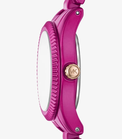 Close-up side view of Michael Kors pink-tone petite watch with fluted bezel and rose gold MK logo crown