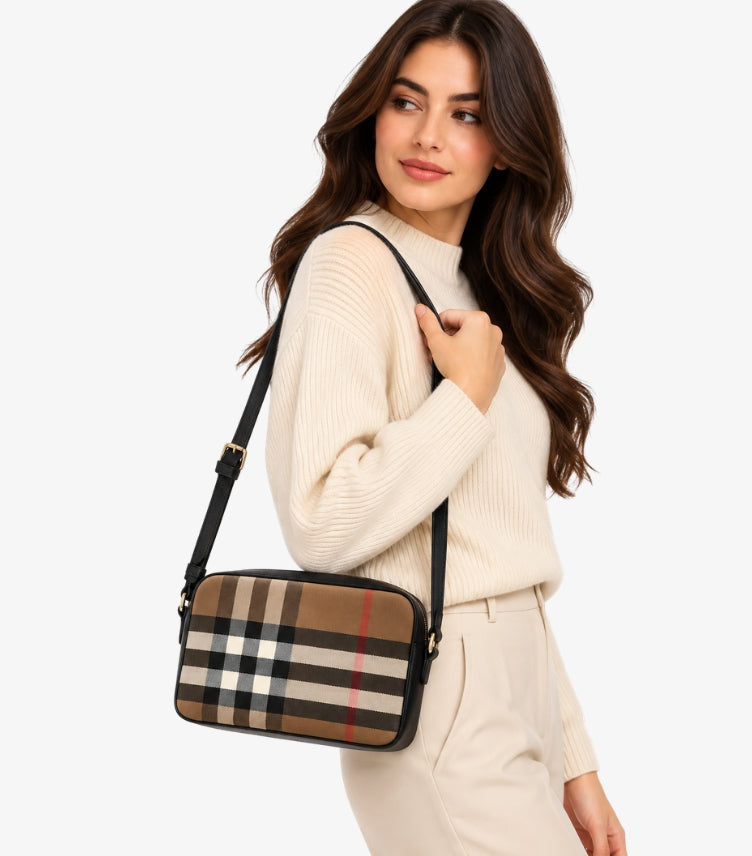 Woman wearing a Burberry Vintage Check camera bag with an adjustable black crossbody strap