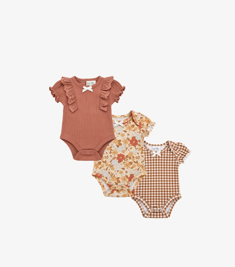Nicole Miller New York baby girls' 3-pack ruffle sleeve bodysuits featuring dusty rose ribbed fabric, floral prints, brown gingham checks and bow accents.