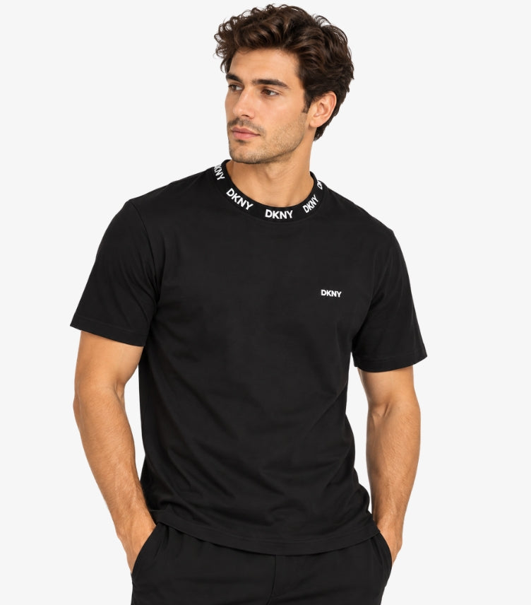 Man wearing a DKNY black short-sleeve crew-neck T-shirt with repeat neckline branding and a small chest logo