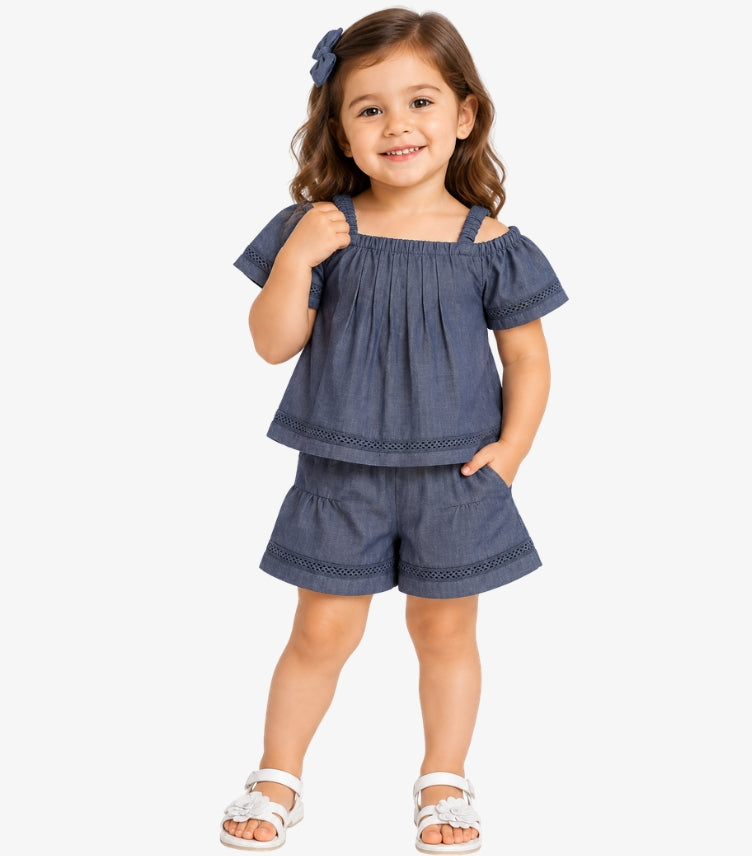 Girl wearing a Calvin Klein denim-blue cold-shoulder top and matching shorts set with decorative openwork trim
