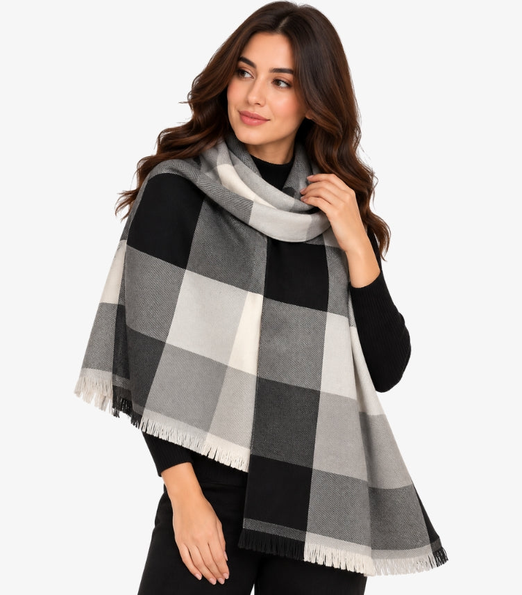 Woman wearing a Calvin Klein oversized black, grey and cream checked shawl with fringed edges