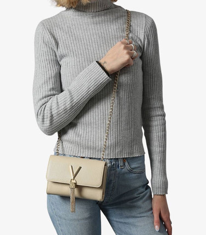 Woman wearing Valentino by Mario Valentino ivory V-logo tassel crossbody bag with gold chain strap