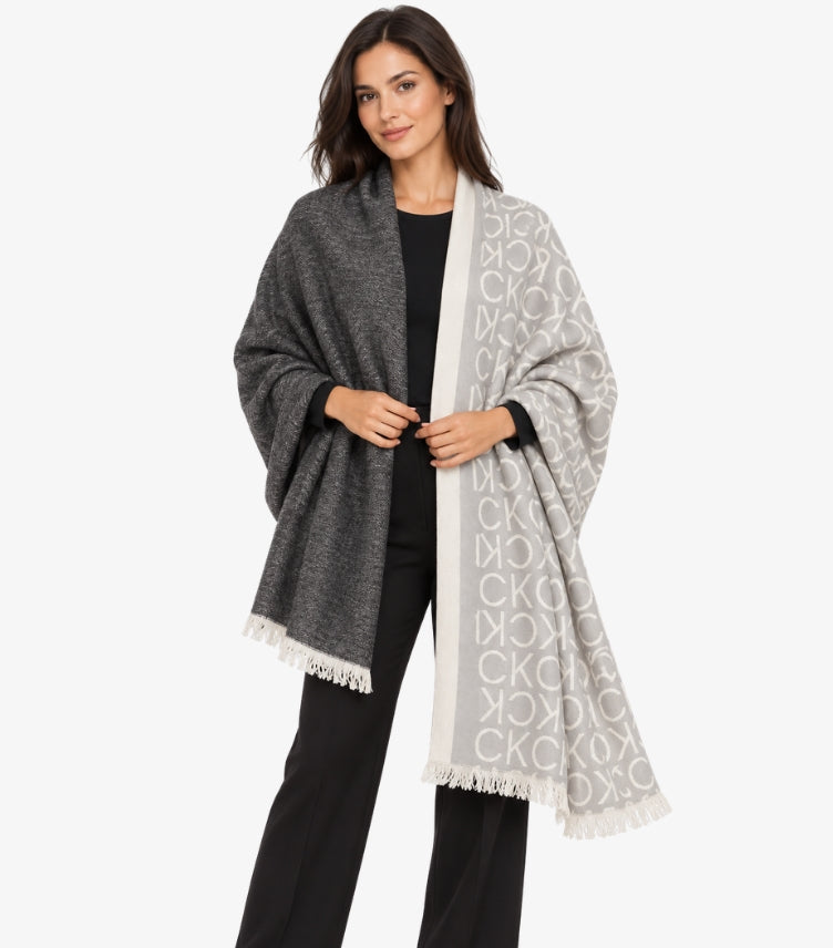 Calvin Klein Women's Grey and White Monogram Shawl featuring signature CK logo pattern, contrasting two-tone design and fringed edges, styled on a female model.