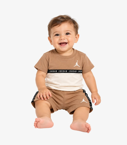 Baby wearing a Jordan two-piece outfit with a brown and cream Jumpman T-shirt and matching logo-tape shorts