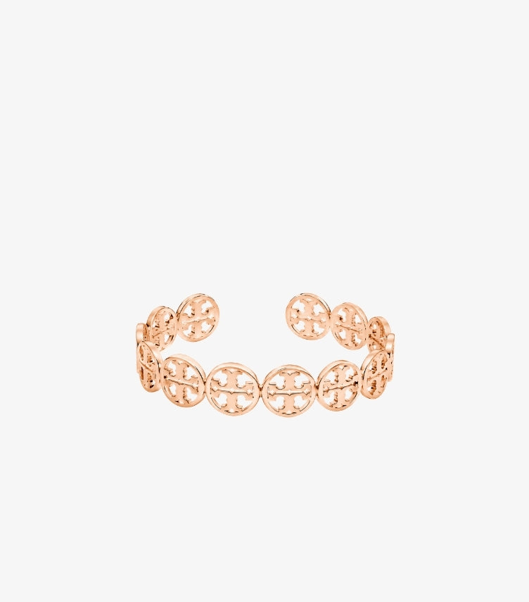 Front view of Tory Burch rose gold-tone open cuff bracelet with repeating circular Double T logo medallions