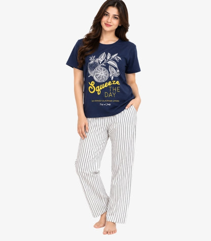 Front view of a model wearing a Marks & Spencer Squeeze the Day graphic pyjama set with striped bottoms and side pockets