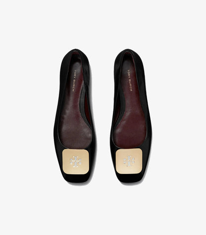 Top view of Tory Burch black square-toe ballet flats with gold logo plaques and burgundy interiors