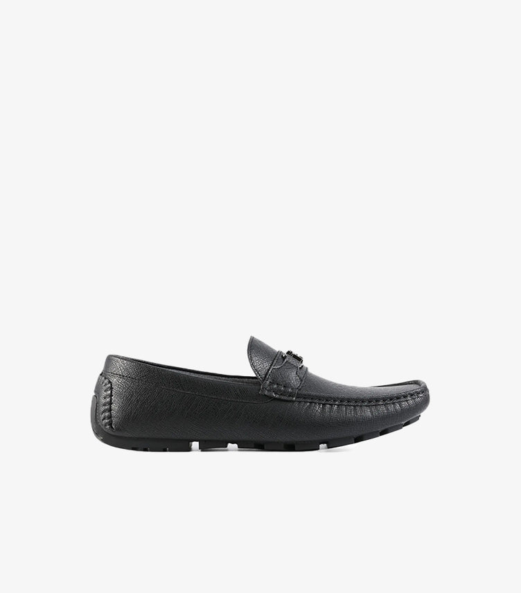 Side profile of Tommy Hilfiger men's black leather driver loafer with hand-stitched moc toe and flexible rubber outsole.