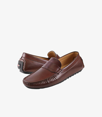 Angled view of Tommy Hilfiger men’s brown leather driving loafers with apron-toe stitching and branded heel detail