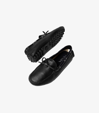 Model wearing Prada men’s leather driving moccasins with tailored trousers for a smart-casual look