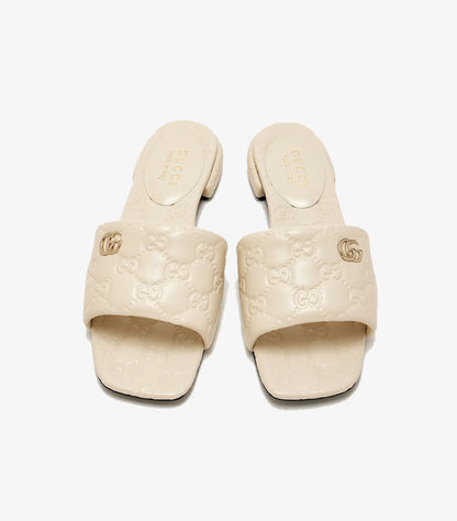 Gucci GG Matelassé cream leather flat slides top view showing Double G gold logo and GG monogram embossing