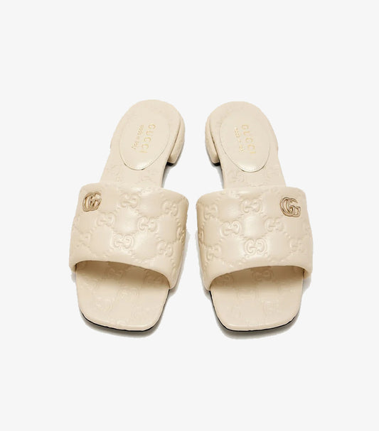 Gucci GG Matelassé cream leather flat slides top view showing Double G gold logo and GG monogram embossing