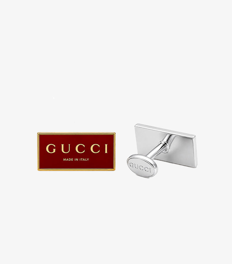 Gucci red enamel cufflink front face with gold GUCCI Made in Italy lettering alongside silver-tone T-bar toggle back mechanism with engraved GUCCI oval toggle