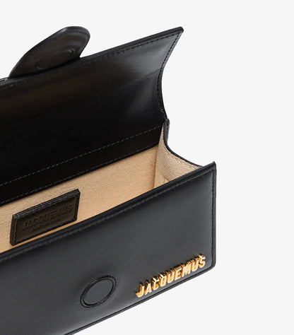 Open Jacquemus Le Bambino Long bag showing beige-lined interior and magnetic closure