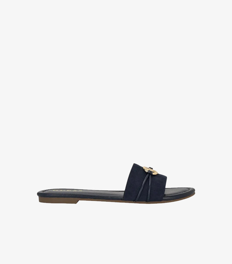 Side view of Guess women’s navy blue flat slide sandal with gold-tone logo hardware
