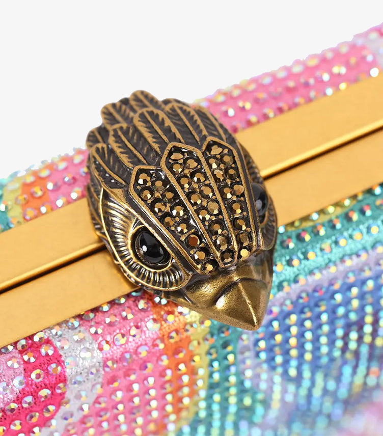 Close-up of Kurt Geiger sculptural eagle-head clasp with crystal detailing on an embellished box clutch
