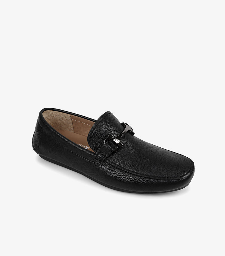 Ferragamo black pebbled leather Gancini driver loafer angled view showing moccasin construction tan lining and rubber pebble driving sole