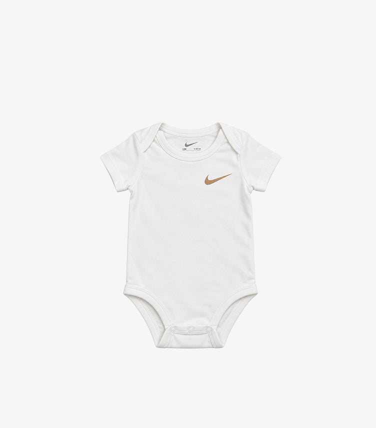 Front view of Nike baby white short-sleeve bodysuit with a gold-tone Swoosh chest logo, envelope neck and bottom poppers
