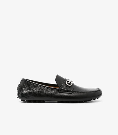 Ferragamo black pebbled leather Gancini driver loafer side profile showing silver Gancini bit and rubber pebble driving sole