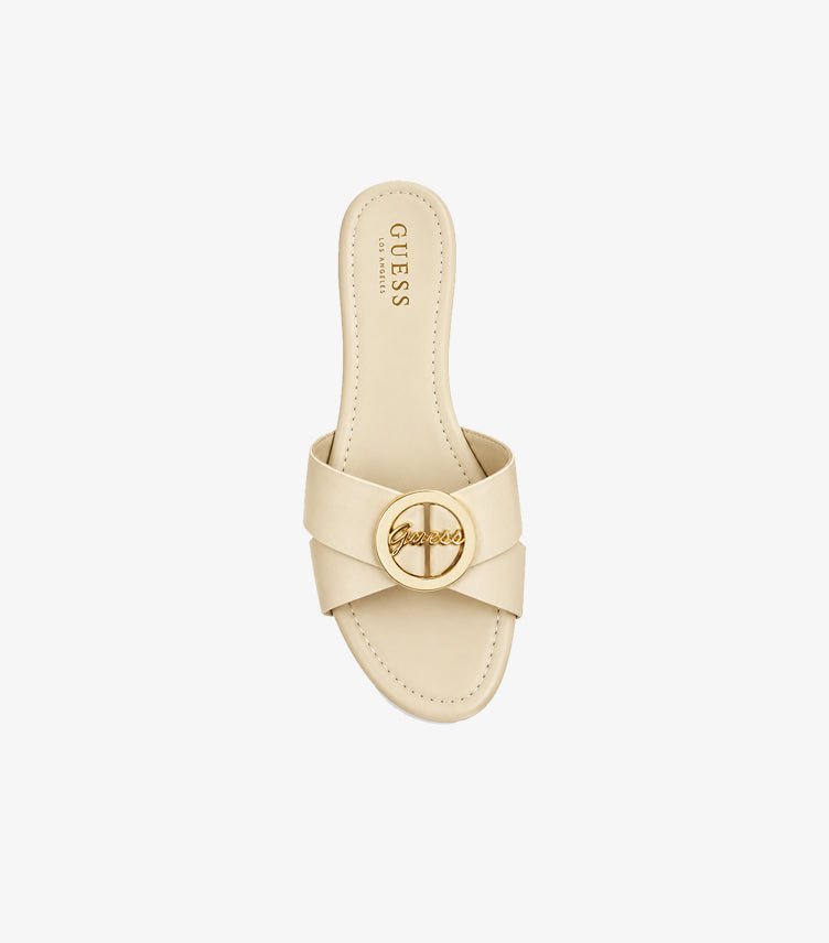 Top view of Guess women’s cream flat slide with crossover straps, gold-tone logo medallion and branded footbed