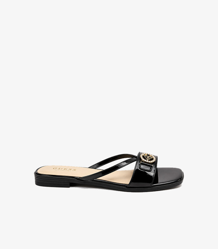 Side view of Guess women’s black patent flat sandal with crossover straps and crystal logo