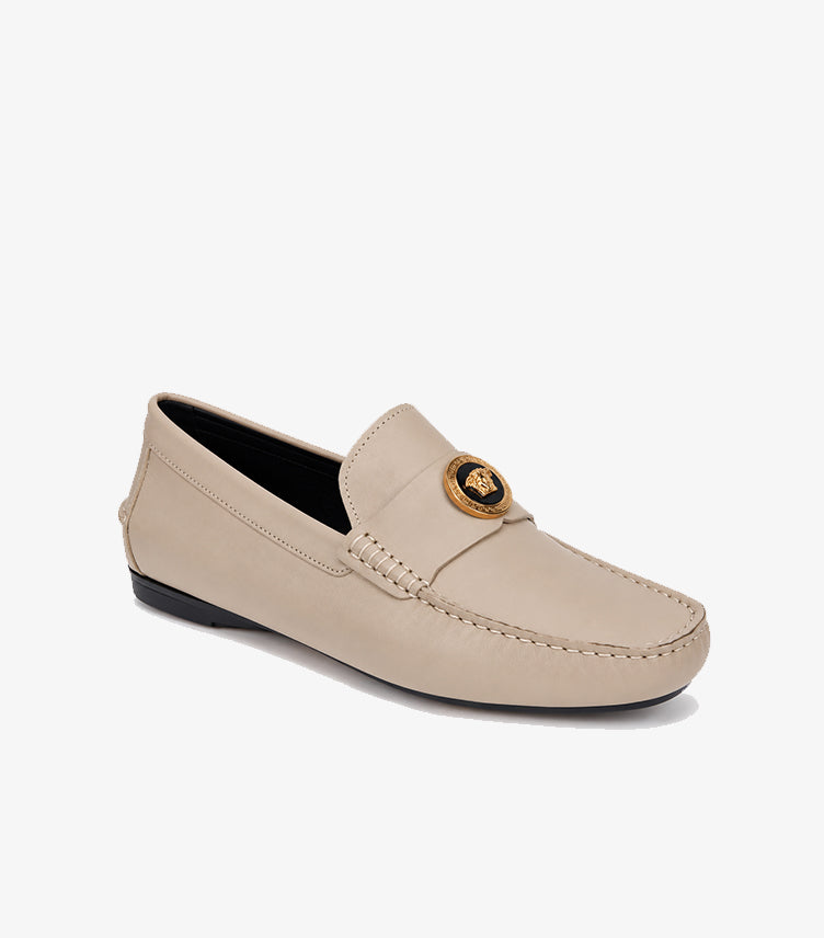 Angled view of Versace beige leather driver loafers