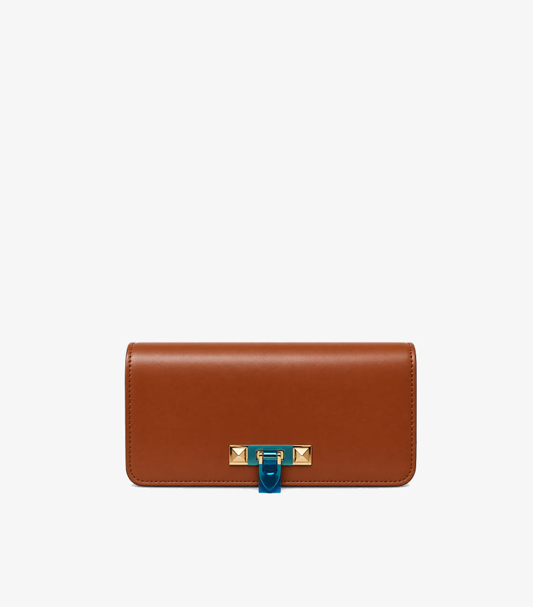 Model wearing a Valentino brown shoulder bag with a gold-tone chain strap and studded front clasp