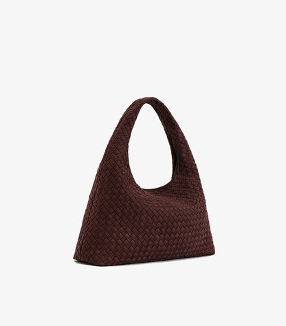 Angled view of JW PEI woven tote bag showing its interlaced texture, side profile and broad base
