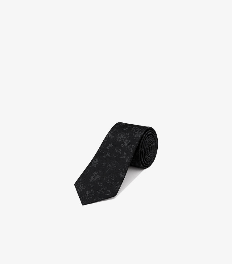 Rolled Tommy Hilfiger men’s formal necktie featuring a tonal woven floral jacquard pattern and classic pointed blade