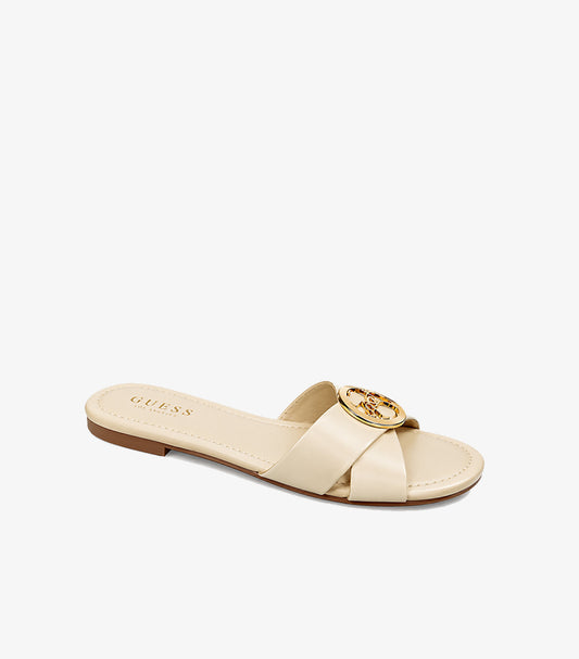 Angled view of Guess women’s cream open-toe slide featuring crossover straps and a gold-tone medallion